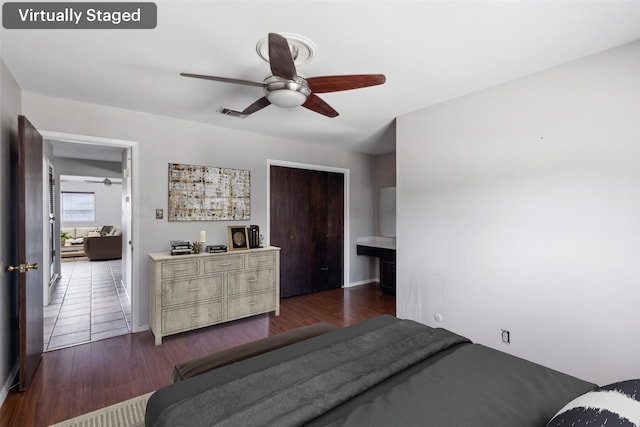 bedroom featuring dark wood-type flooring, a closet, ceiling fan, and baseboards