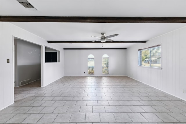 unfurnished living room featuring beam ceiling, visible vents, and plenty of natural light