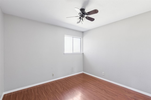 spare room with ceiling fan, baseboards, and wood finished floors