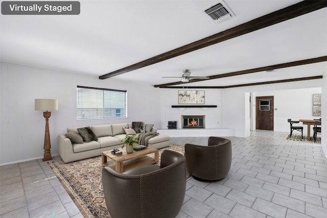 living area with light tile patterned floors, ceiling fan, a fireplace, visible vents, and beam ceiling