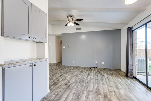 kitchen featuring ceiling fan, gray cabinets, lofted ceiling with beams, and light hardwood / wood-style flooring