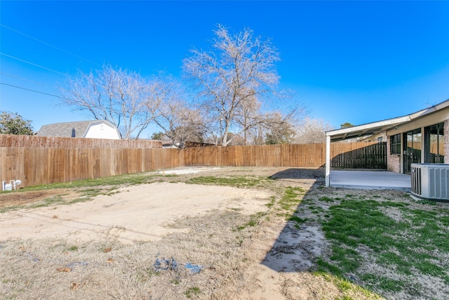 view of yard with central AC and a patio