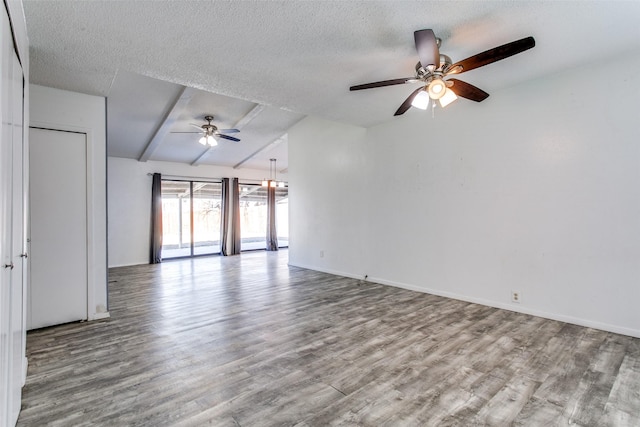 empty room with ceiling fan, light hardwood / wood-style floors, lofted ceiling with beams, and a textured ceiling