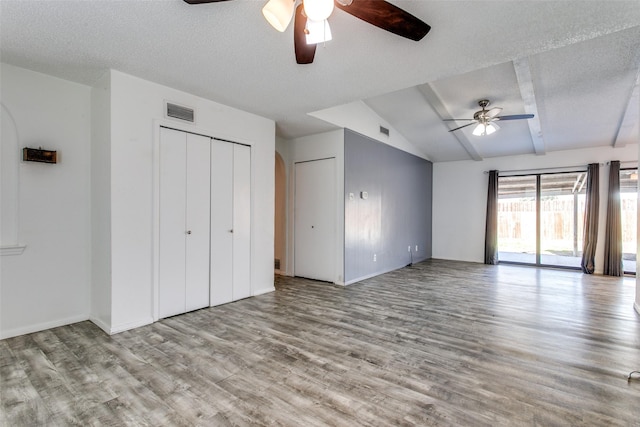 unfurnished bedroom with lofted ceiling, ceiling fan, a textured ceiling, and light wood-type flooring