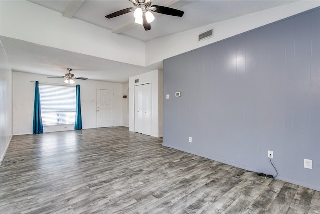 empty room featuring ceiling fan, beam ceiling, and light hardwood / wood-style flooring