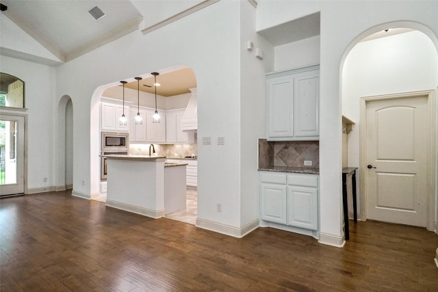 kitchen featuring tasteful backsplash, stainless steel appliances, hanging light fixtures, and white cabinets