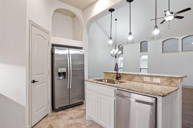 kitchen featuring sink, a center island with sink, appliances with stainless steel finishes, light stone countertops, and white cabinets