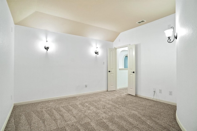 empty room featuring carpet and lofted ceiling