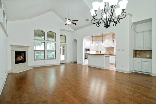 unfurnished living room featuring dark wood-type flooring, ceiling fan, and high vaulted ceiling