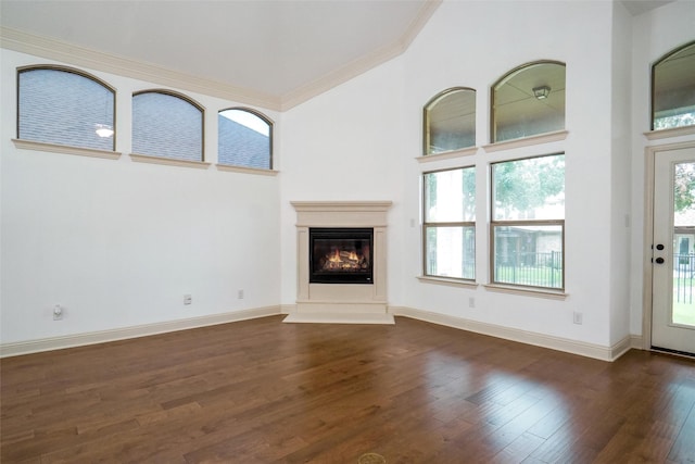 unfurnished living room featuring crown molding, dark hardwood / wood-style floors, and a towering ceiling