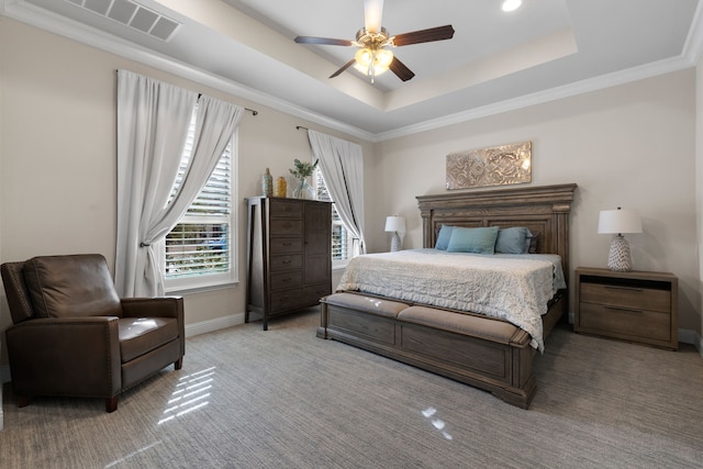 bedroom with a tray ceiling, ornamental molding, ceiling fan, and carpet