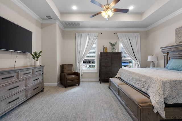 bedroom featuring crown molding, ceiling fan, a tray ceiling, and light carpet