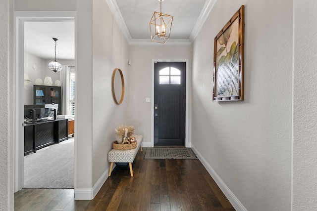 entrance foyer with dark hardwood / wood-style flooring, ornamental molding, and a chandelier