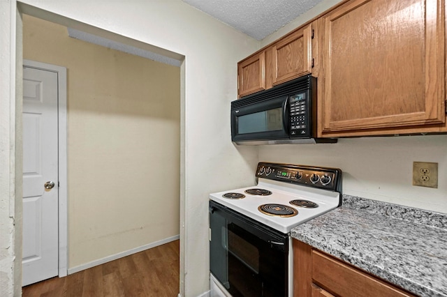 kitchen with hardwood / wood-style floors, range with electric cooktop, and a textured ceiling