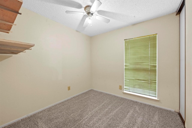 spare room with ceiling fan, carpet, and a textured ceiling