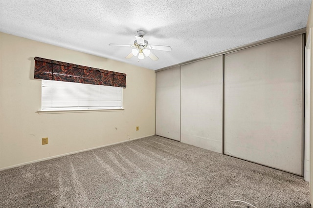 unfurnished bedroom with a textured ceiling, a closet, ceiling fan, and carpet flooring