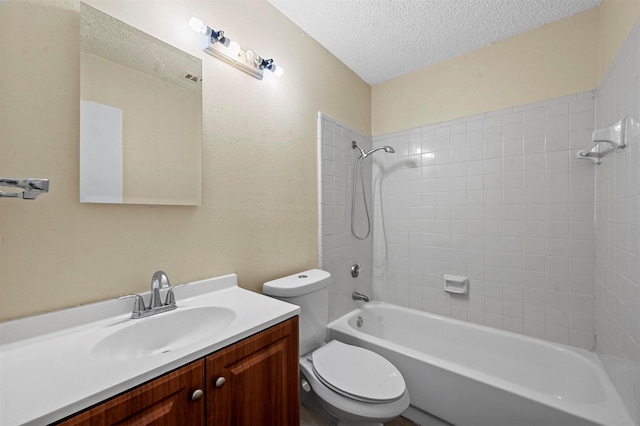 full bathroom with tiled shower / bath combo, vanity, a textured ceiling, and toilet