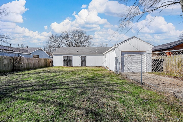 rear view of property with a garage and a yard