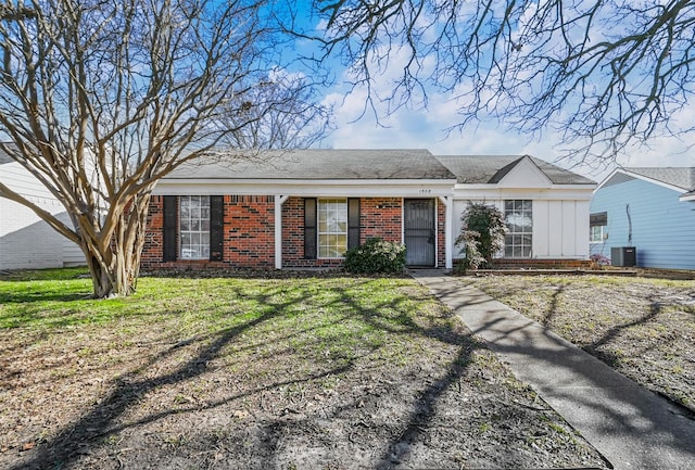 ranch-style home featuring cooling unit and a front yard