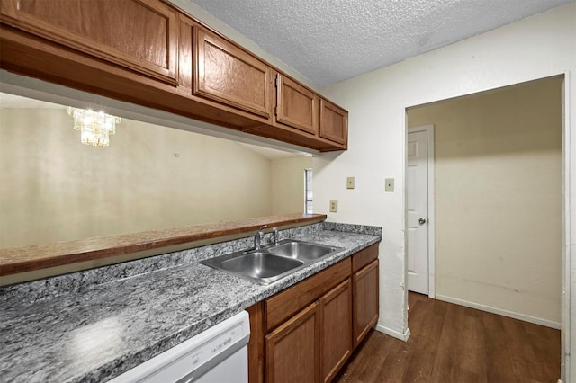 kitchen with dark wood-type flooring, white dishwasher, sink, and a textured ceiling