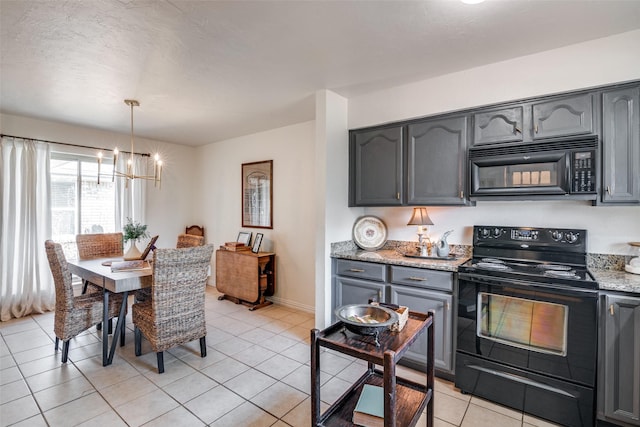 kitchen with light stone countertops, decorative light fixtures, gray cabinets, and black appliances