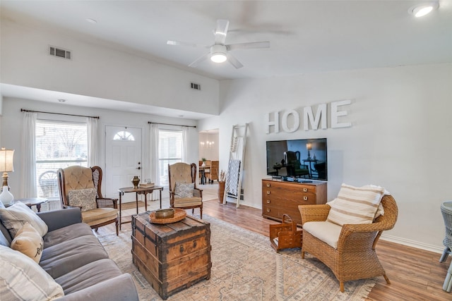 living room with ceiling fan, lofted ceiling, and light hardwood / wood-style flooring