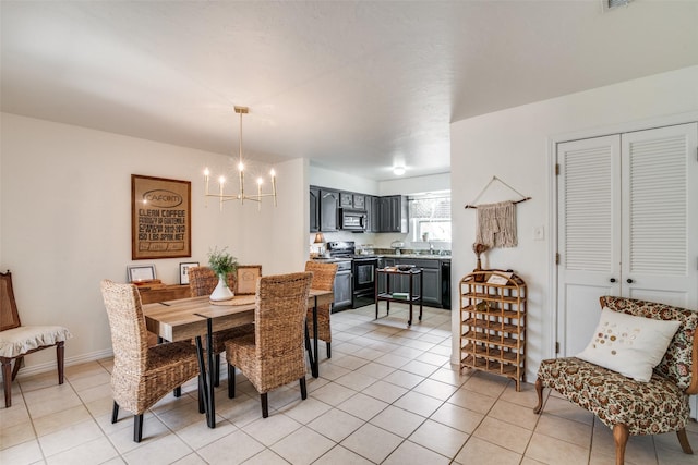 dining room with a notable chandelier, sink, and light tile patterned flooring