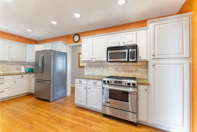 kitchen featuring light stone counters, light hardwood / wood-style floors, white cabinets, and appliances with stainless steel finishes