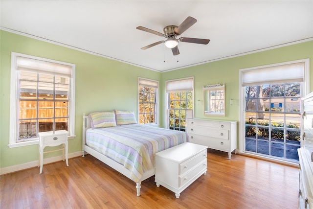 bedroom featuring multiple windows, access to exterior, ceiling fan, and light hardwood / wood-style floors