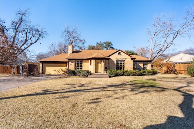 ranch-style home featuring a chimney, fence, concrete driveway, and brick siding