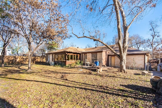 back of property featuring a yard and a sunroom