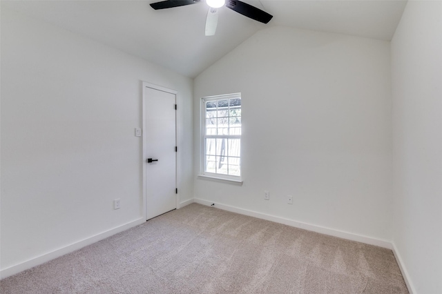 carpeted spare room featuring lofted ceiling and ceiling fan