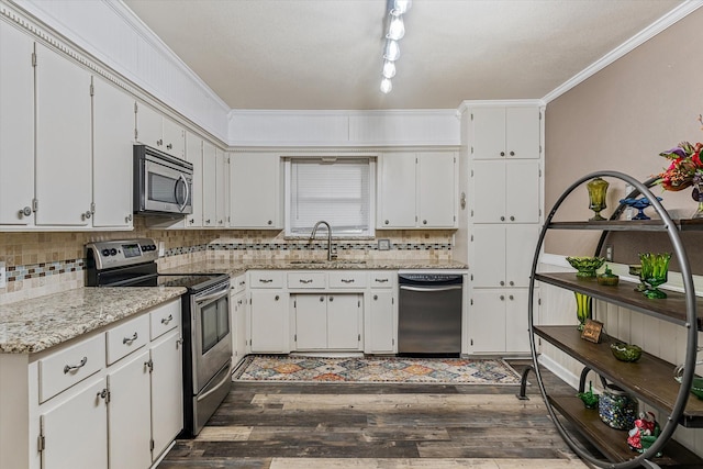 kitchen with sink, dark wood-type flooring, appliances with stainless steel finishes, light stone countertops, and white cabinets