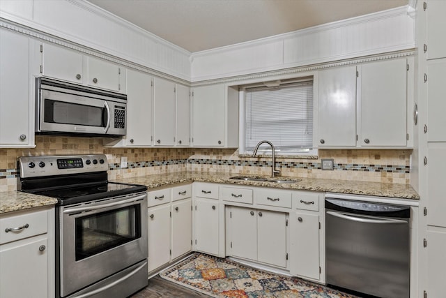 kitchen featuring dark hardwood / wood-style floors, sink, white cabinets, ornamental molding, and stainless steel appliances