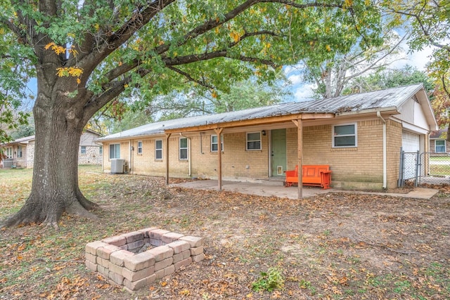 back of property featuring central AC, a patio area, and a fire pit