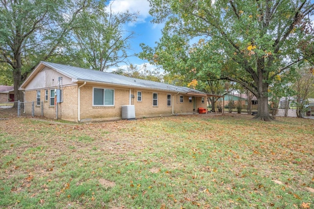 back of house featuring a yard and central AC unit