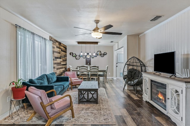 living room with dark hardwood / wood-style flooring, ceiling fan, a fireplace, and a textured ceiling