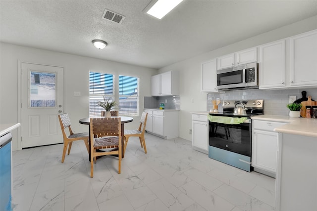 kitchen featuring tasteful backsplash, stainless steel appliances, and white cabinets