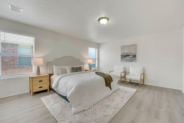 bedroom featuring a textured ceiling and light wood-type flooring