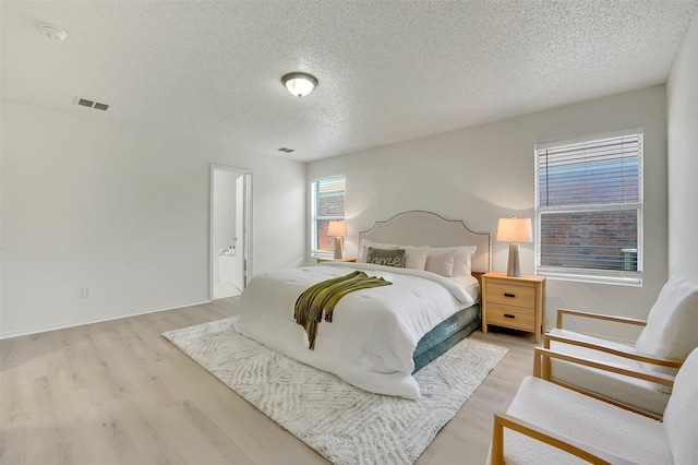 bedroom featuring a textured ceiling and light hardwood / wood-style floors