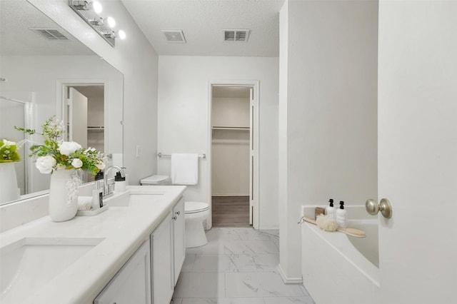 bathroom with vanity, toilet, and a textured ceiling