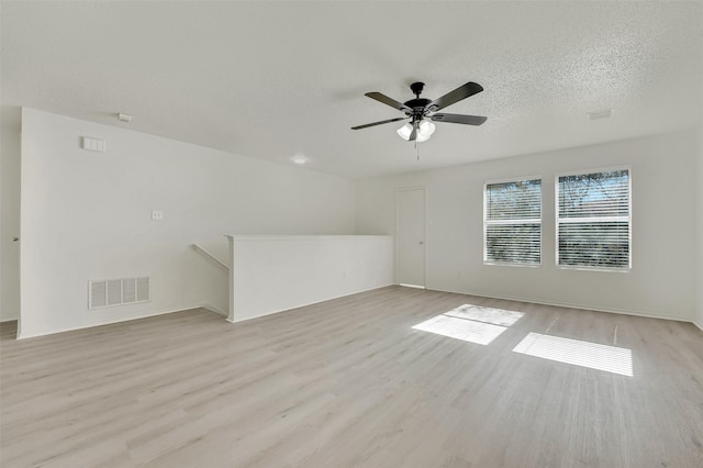 unfurnished room with ceiling fan, light hardwood / wood-style floors, and a textured ceiling