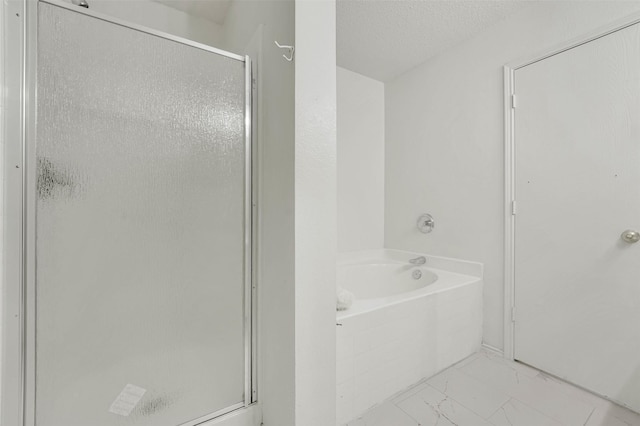 bathroom featuring independent shower and bath and a textured ceiling