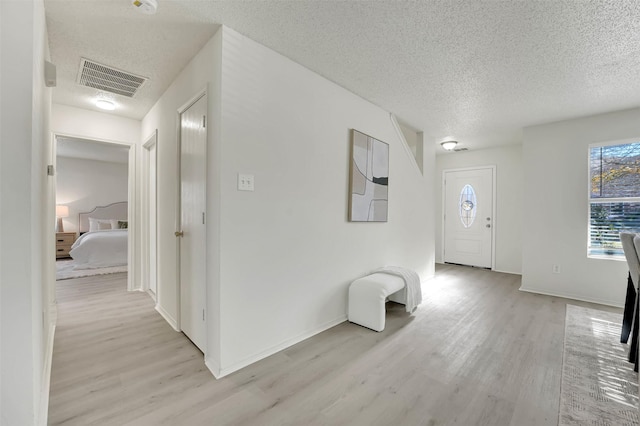 foyer featuring a textured ceiling and light hardwood / wood-style flooring