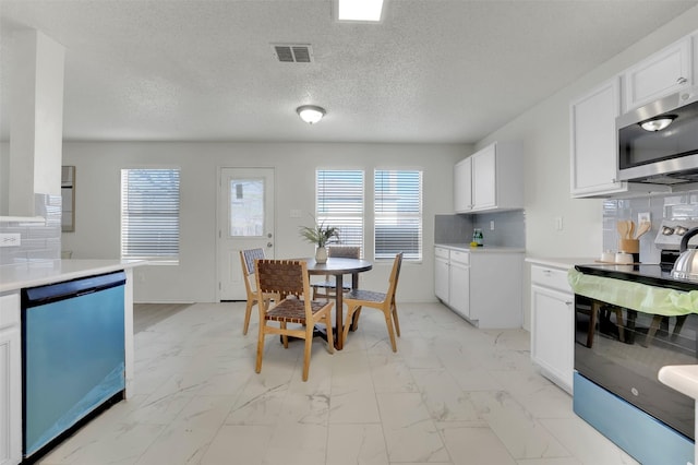 kitchen featuring white cabinetry, appliances with stainless steel finishes, and tasteful backsplash