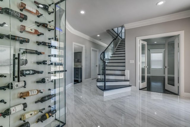 wine cellar featuring ornamental molding, recessed lighting, marble finish floor, and baseboards