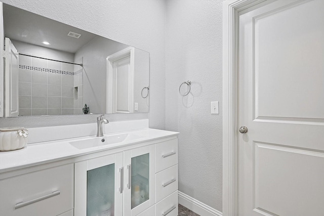 bathroom with vanity and a tile shower