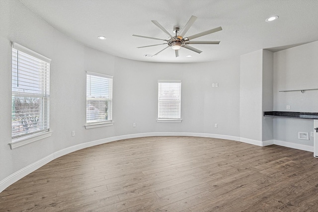 unfurnished living room featuring ceiling fan, wood-type flooring, and a textured ceiling