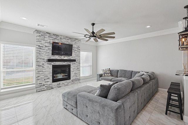 living room featuring a stone fireplace, plenty of natural light, and ornamental molding