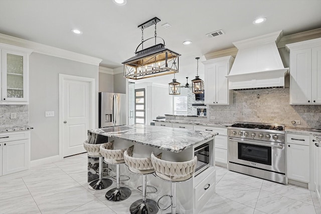 kitchen featuring custom exhaust hood, stainless steel appliances, white cabinets, and a kitchen bar